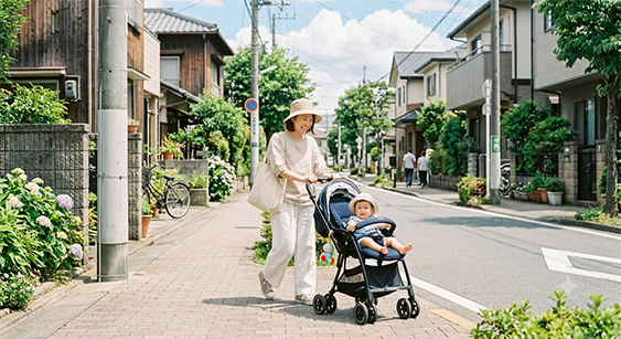 夏の日差しの下でベビーカーを押す親子